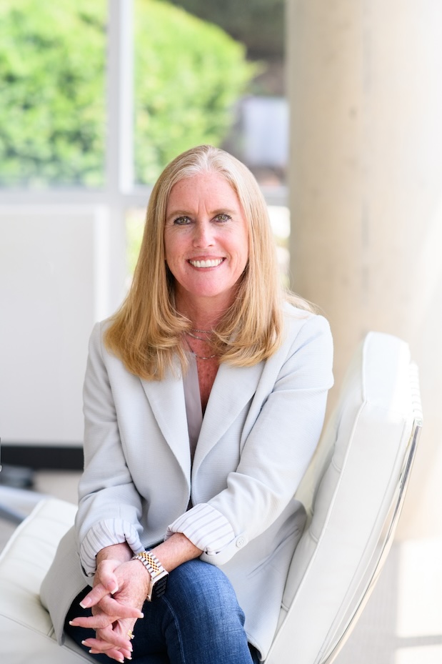 Erin McCabe seated in a light blazer